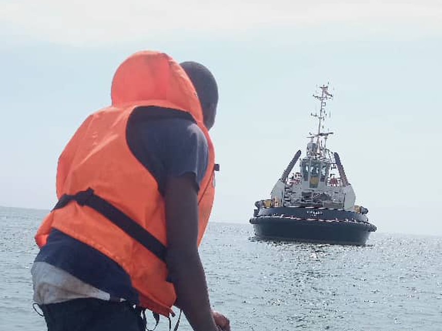 Agent ESM repêchant des filets près d'un remorqueur